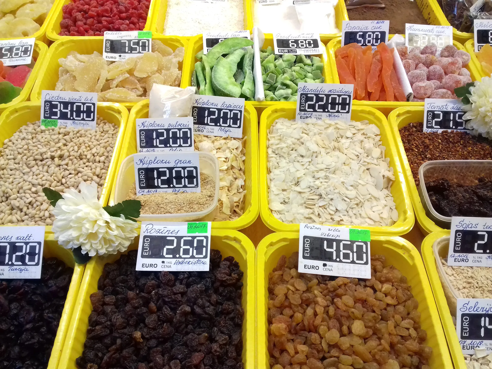 A colourful stall of dried fruit and nuts with euro price tags inside Riga Central Market