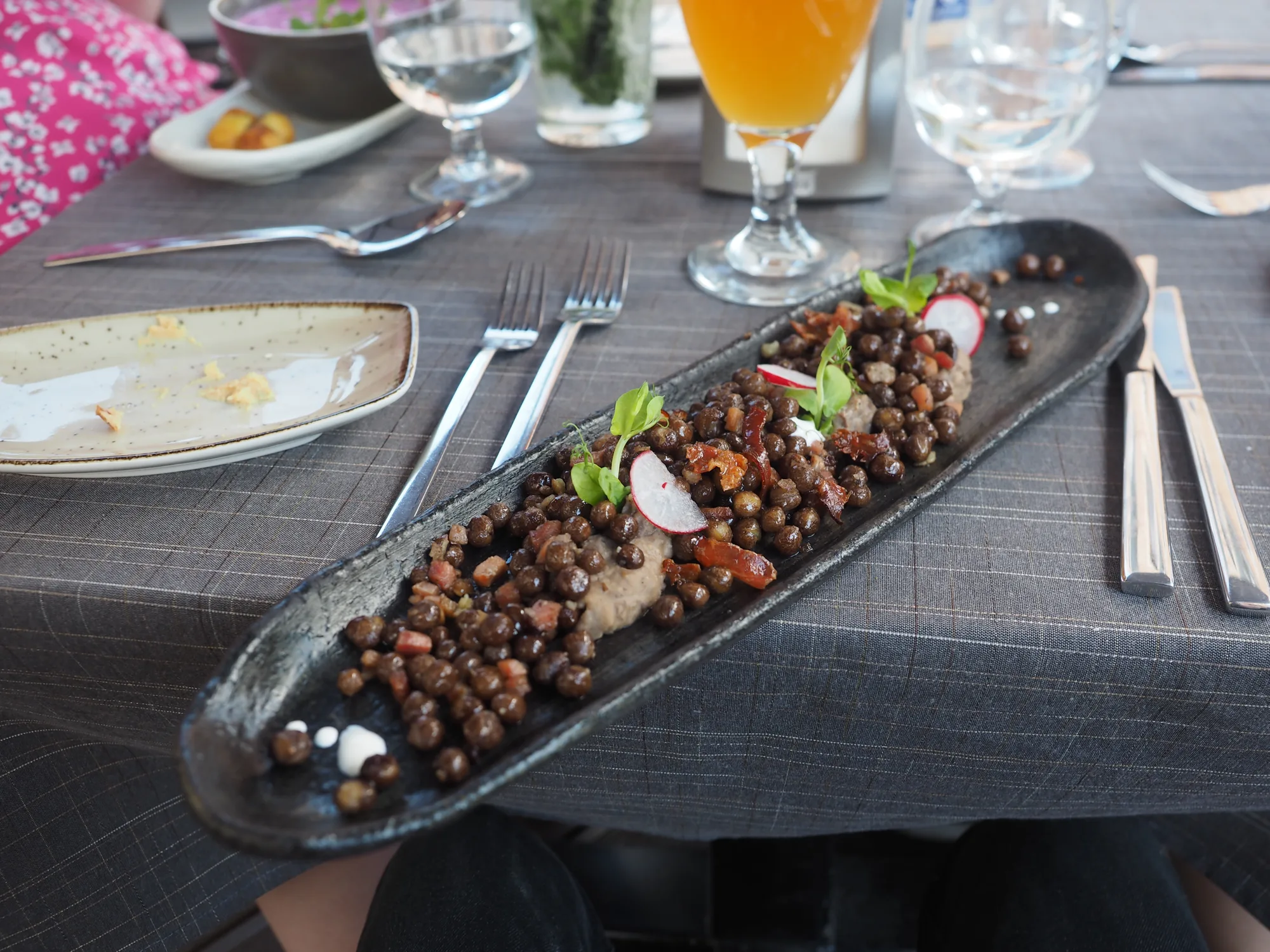 A long black plate of grey peas with bacon (pelēkie zirņi ar speķi), Latvia's national dish, served at a Riga restaurant