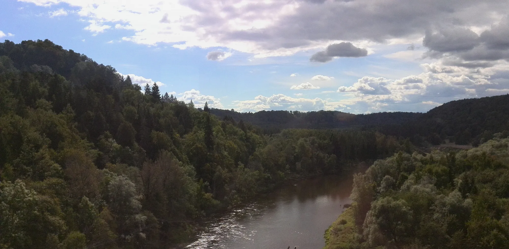 The Gauja river winding through a green forested valley at Sigulda in summer
